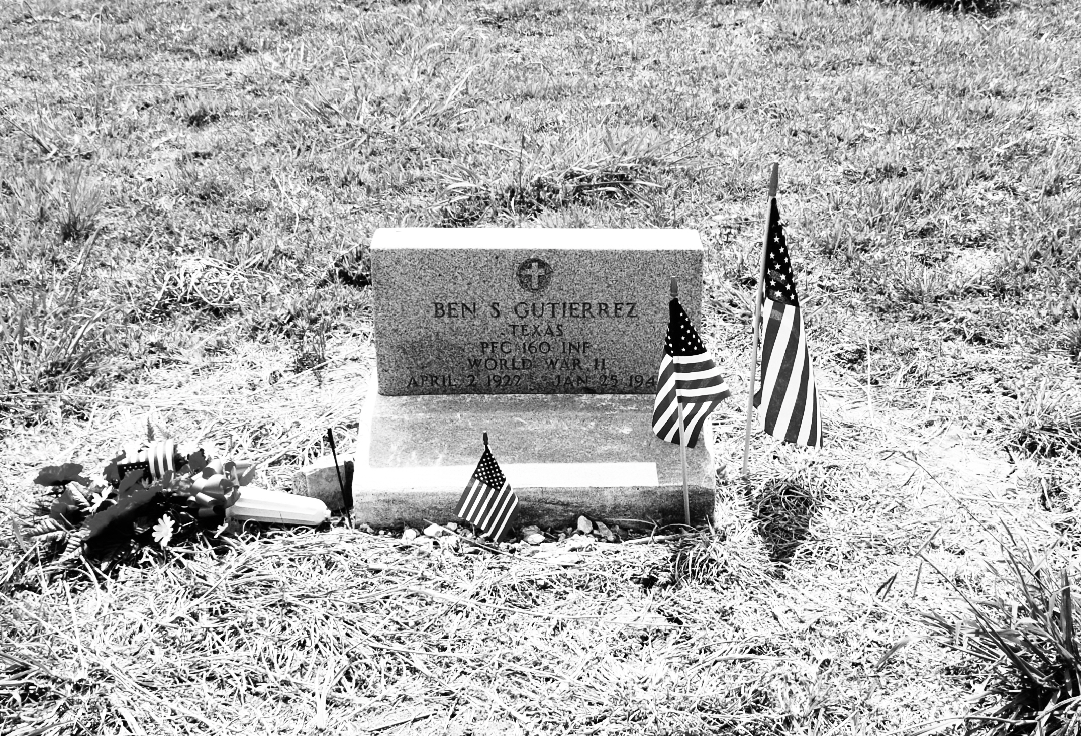 a grave sits in the grass with flags
