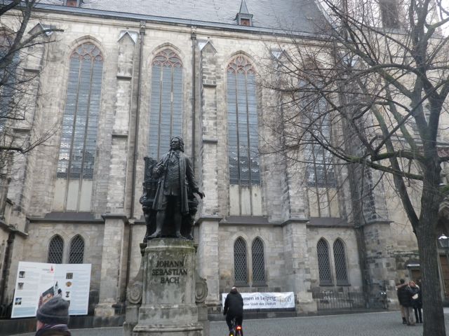 a large church with two statues in front