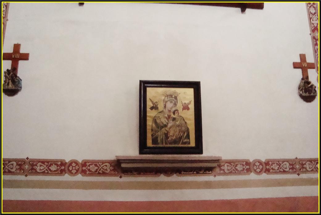 an old religious picture hung next to a cross