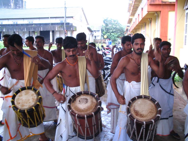 some men playing drums and other instruments on the street