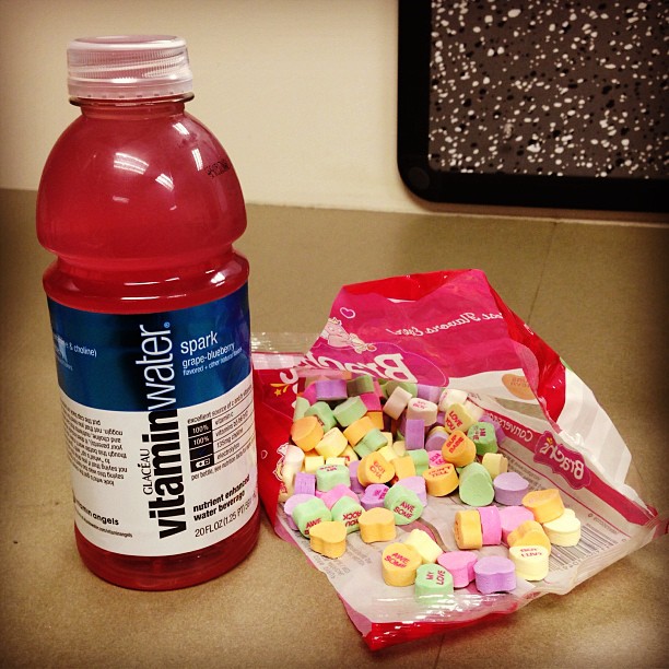 two water bottles one with candy, and the other red