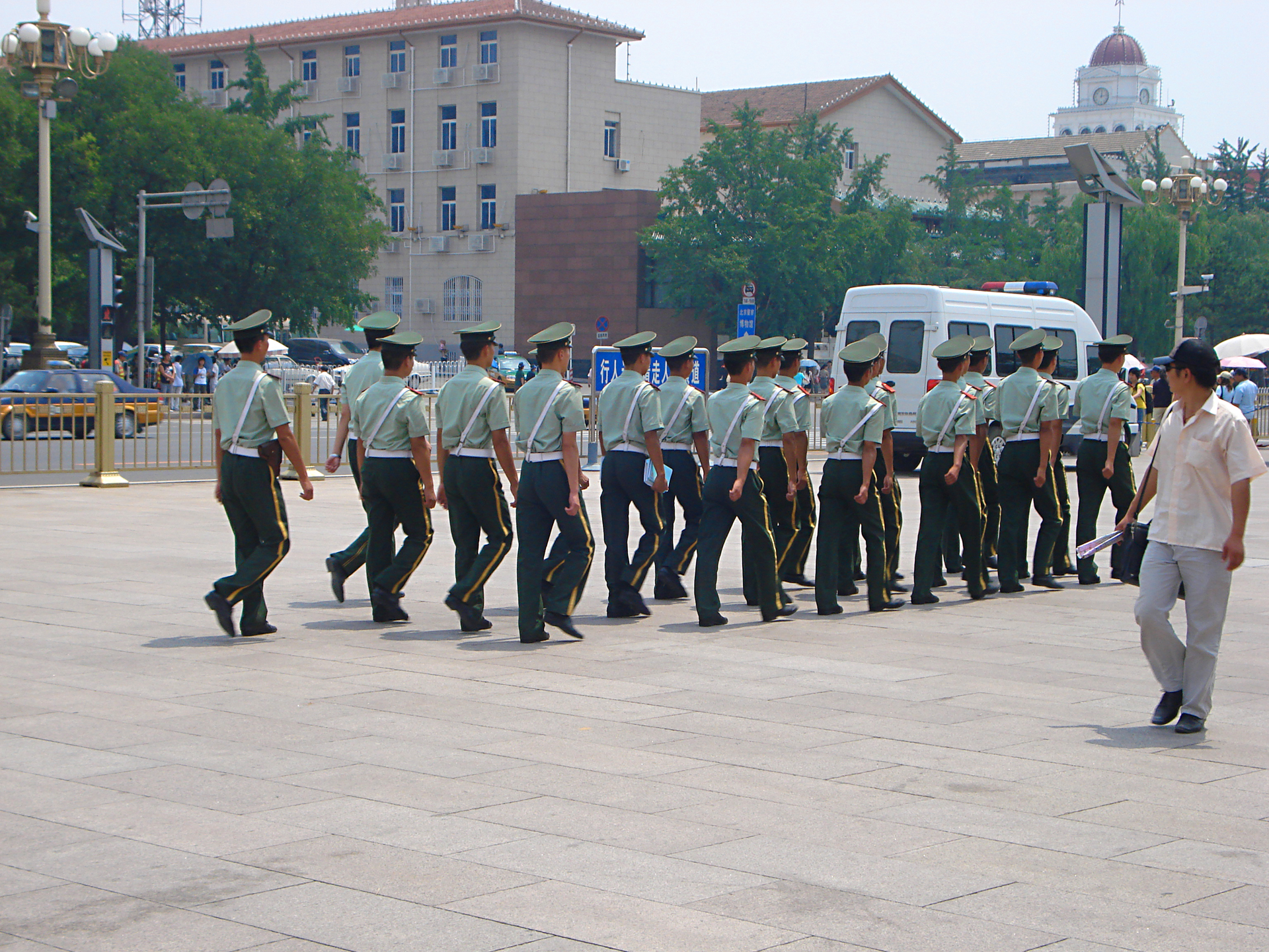 several military men walking on the pavement together