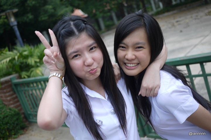 two asian women are posing with one is showing the peace sign