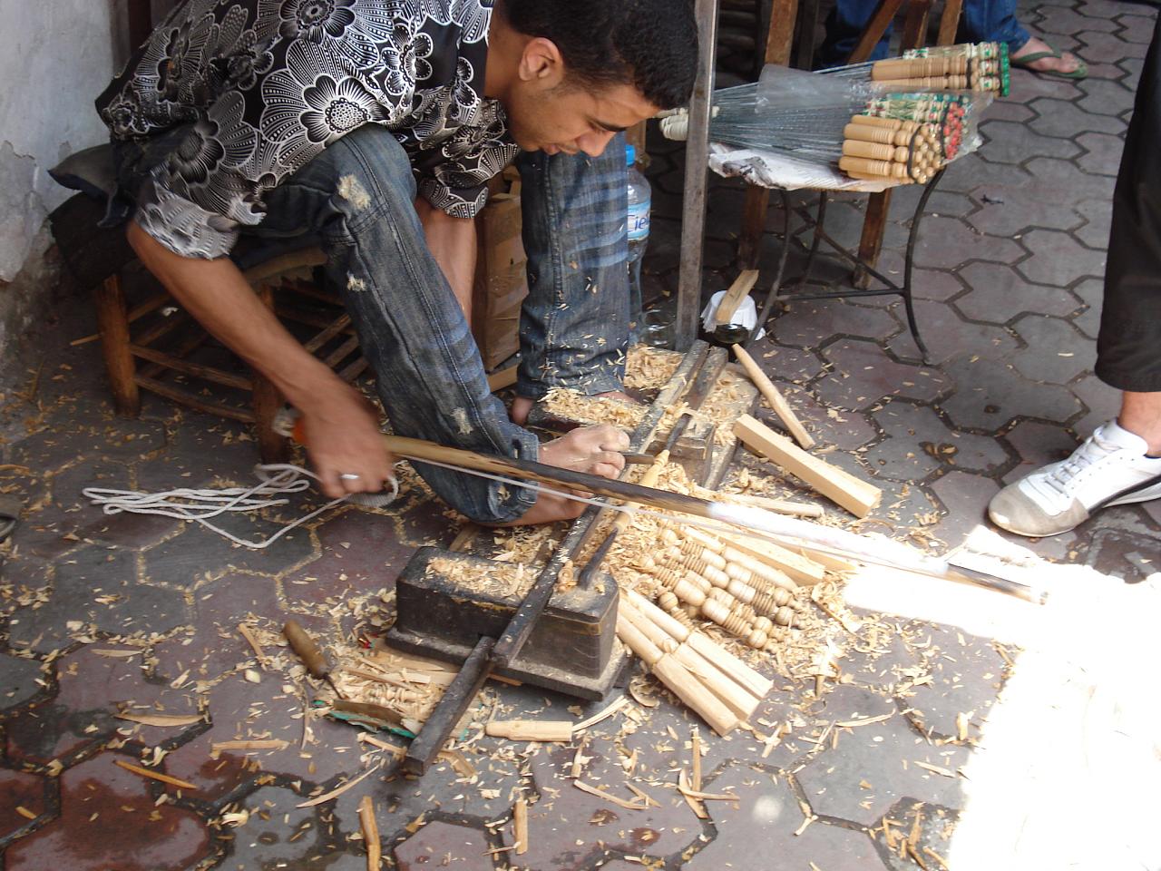 the man is making soing out of wood