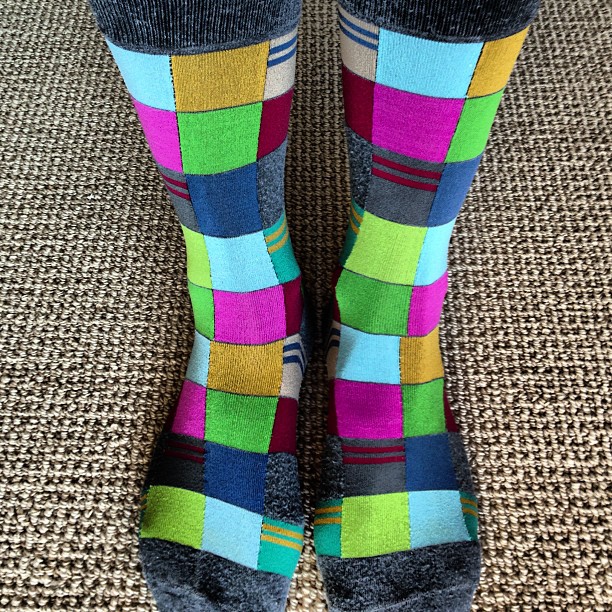 the legs and ankles of a person wearing multicolored socks