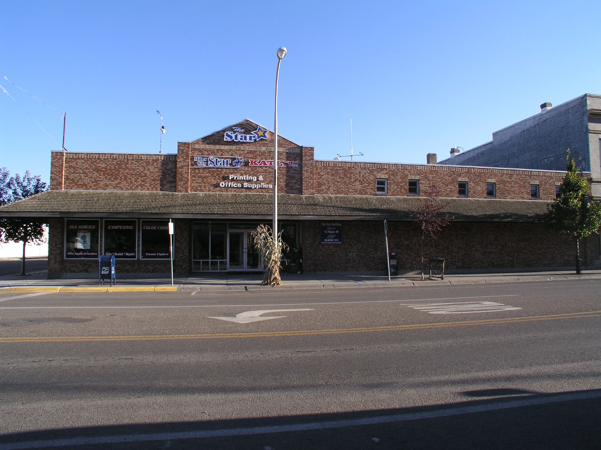 the side of an empty street in front of a brick building