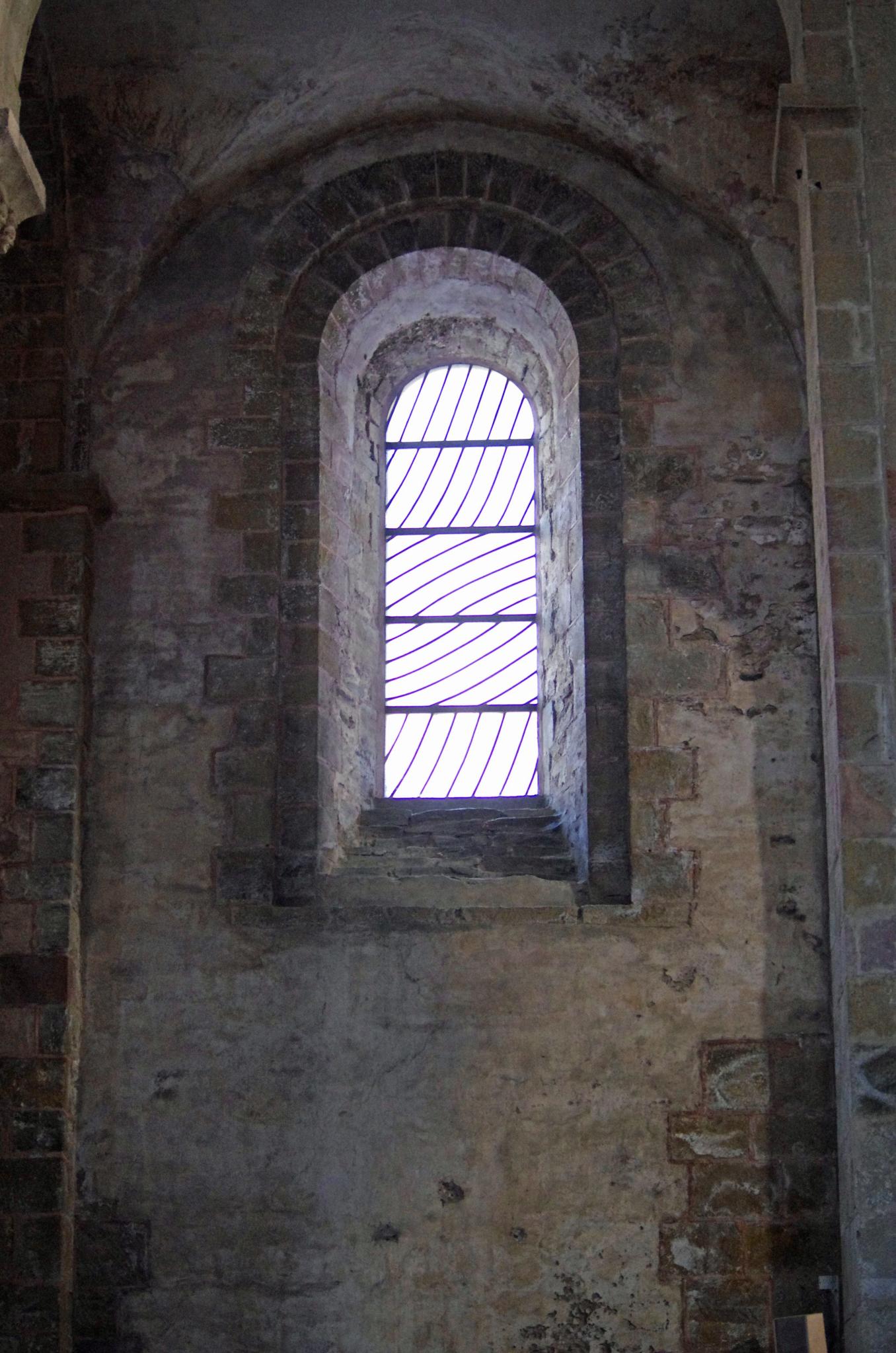 an old stone wall and a window with bars in it