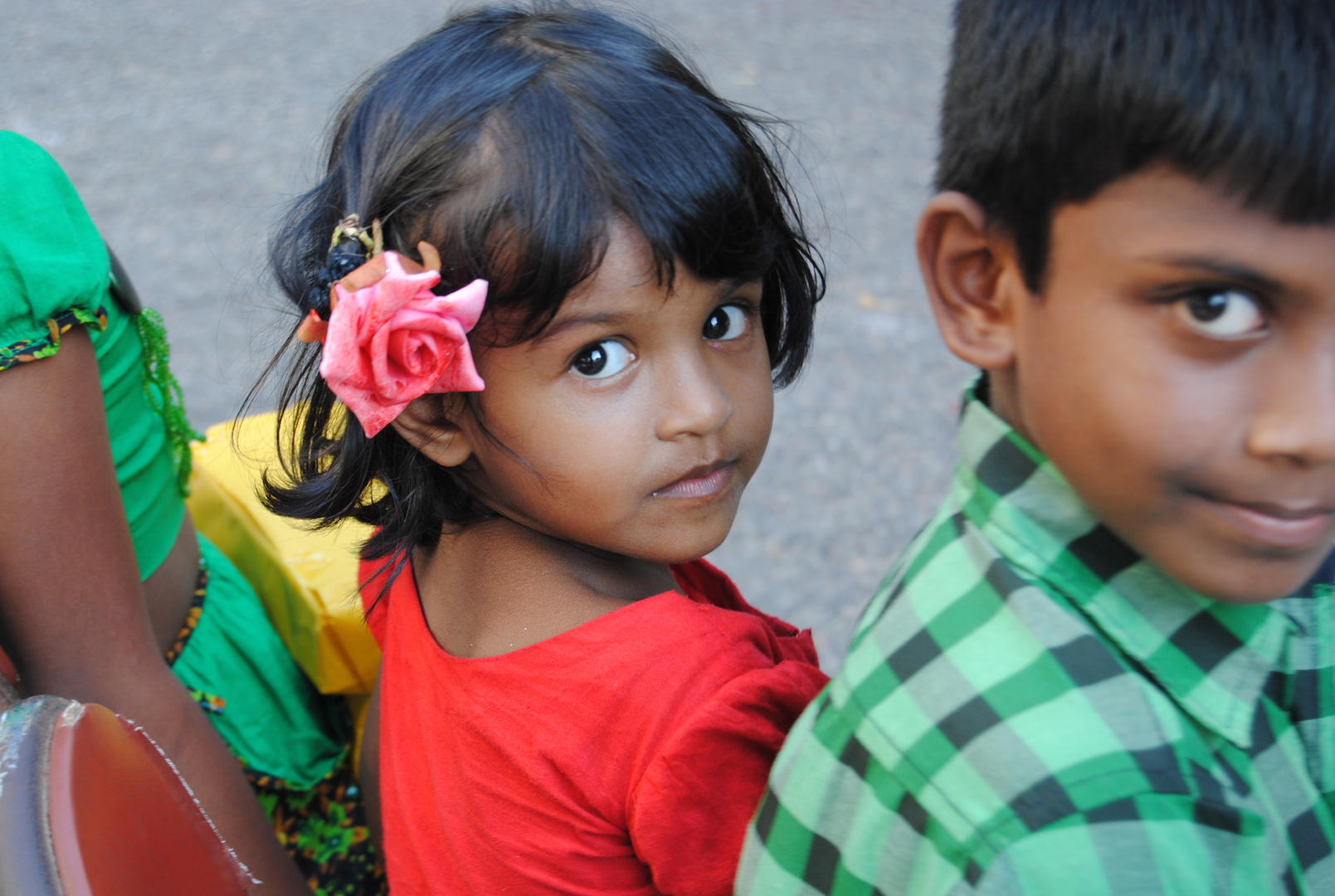 two children in colorful shirts with flowers on their hair