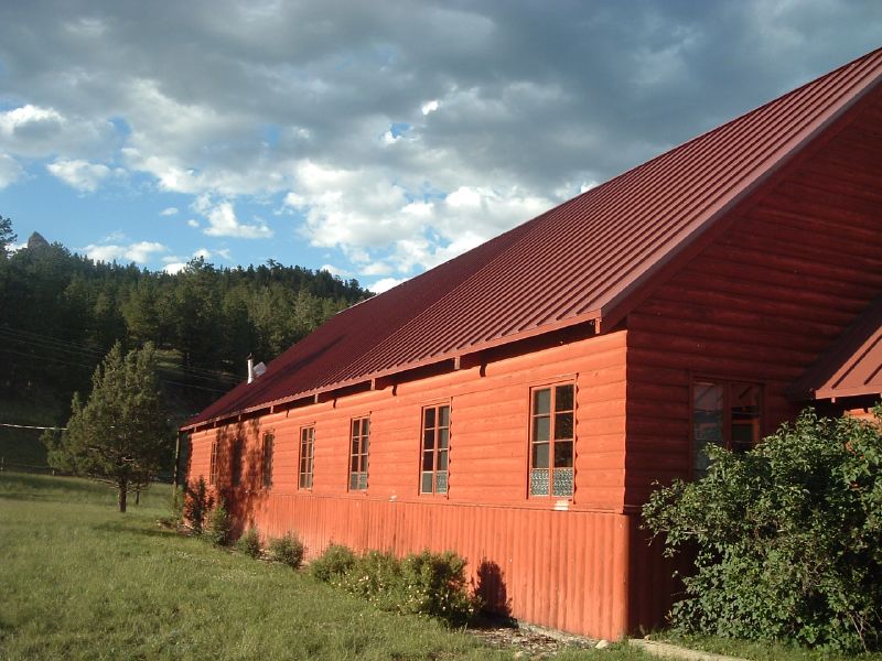 a po of a red barn that is standing out in the wild