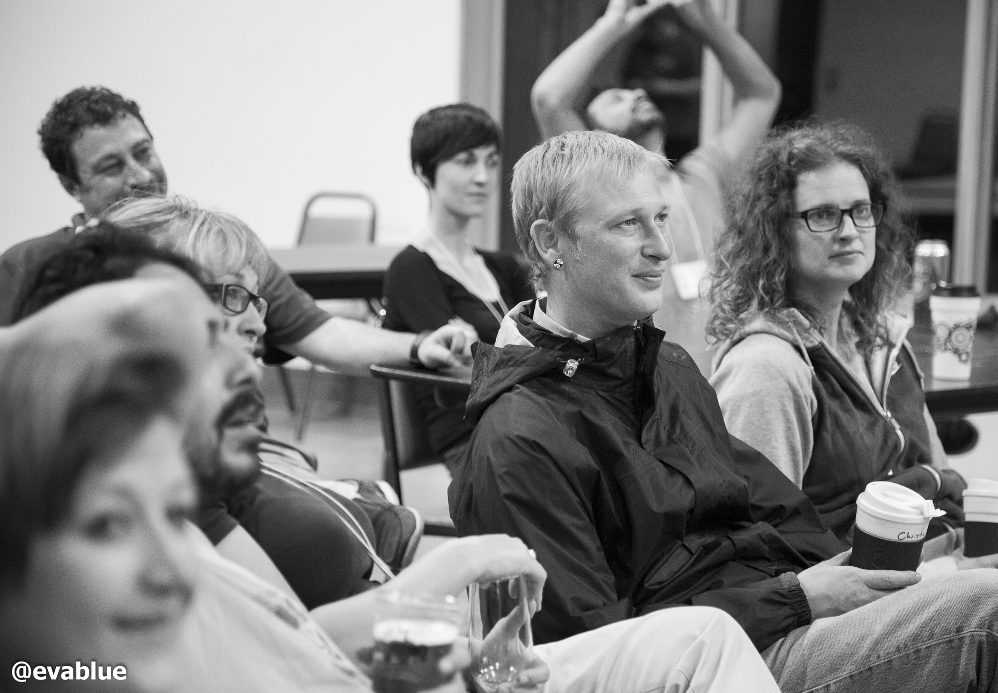 a group of people sitting together and drinking wine