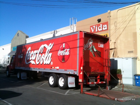 a coca - cola truck is parked near a grocery store