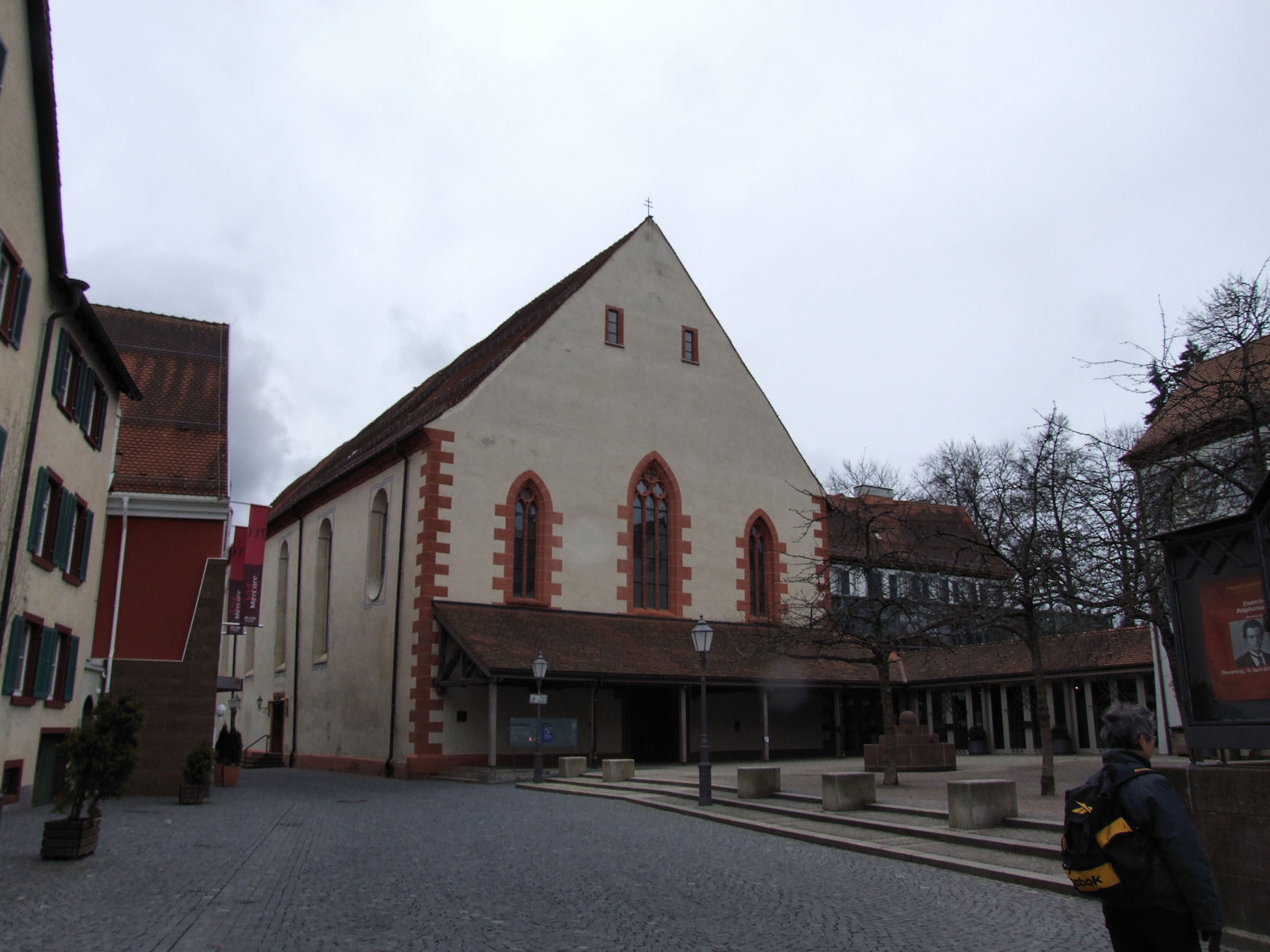 a man walks on a walkway in front of a building