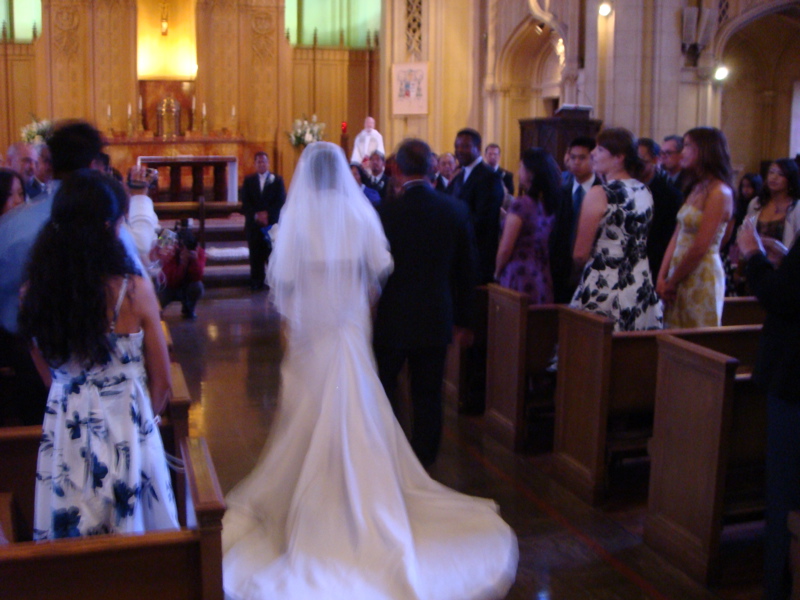 a woman in a wedding dress walks down the aisle at a church