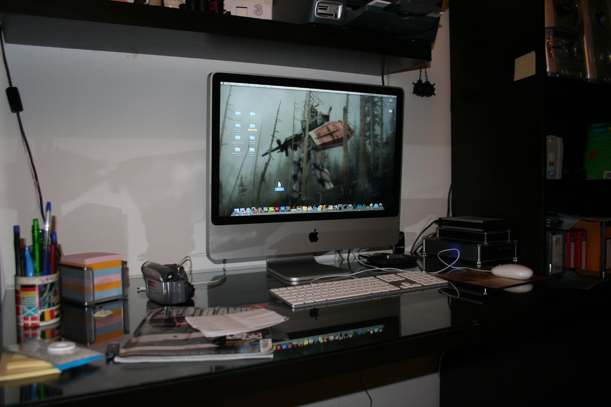 a computer monitor sitting on top of a desk next to books