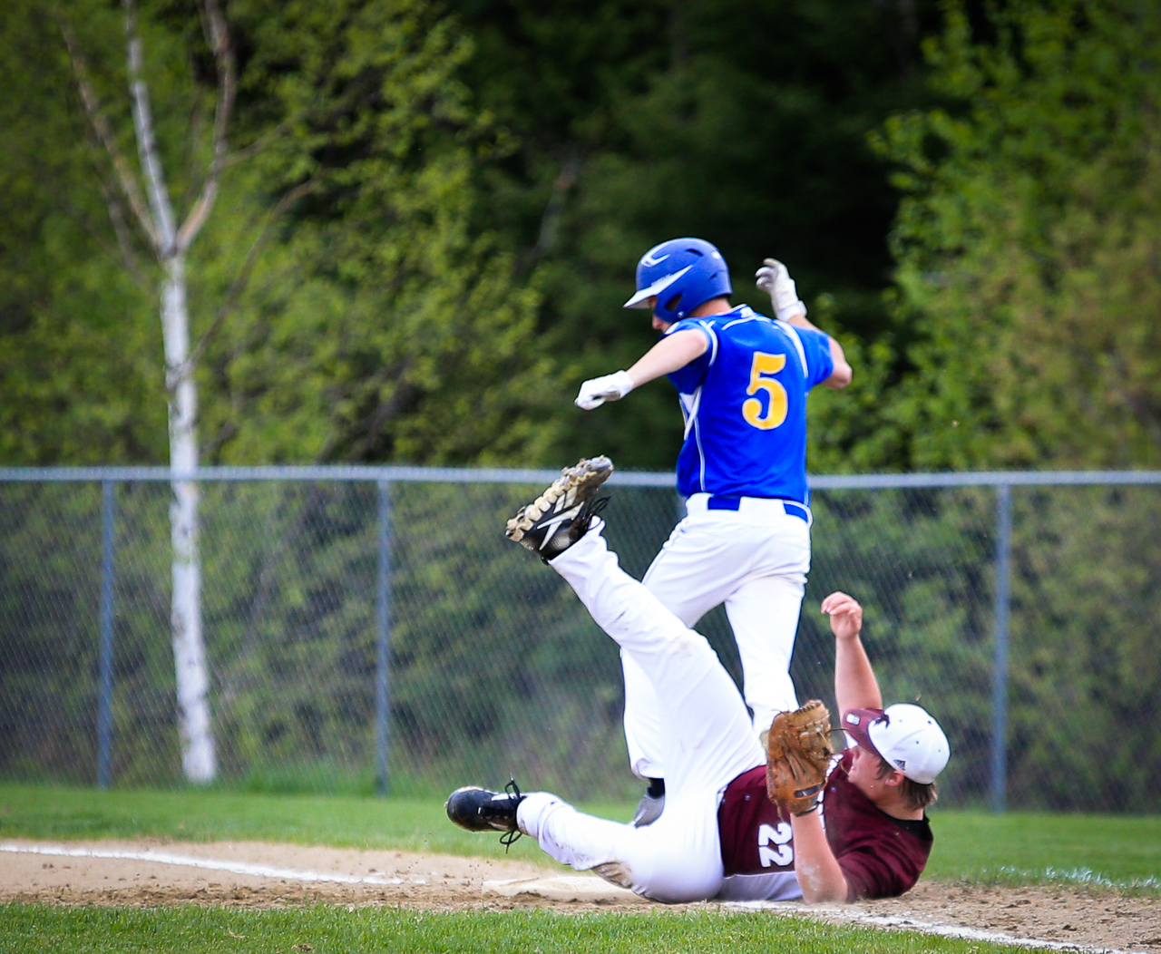 a baseball player sliding into base and taking a slide