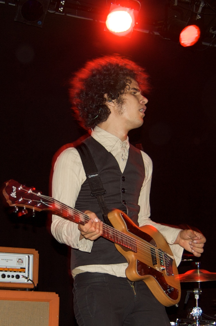 a man with curly hair is holding his bass