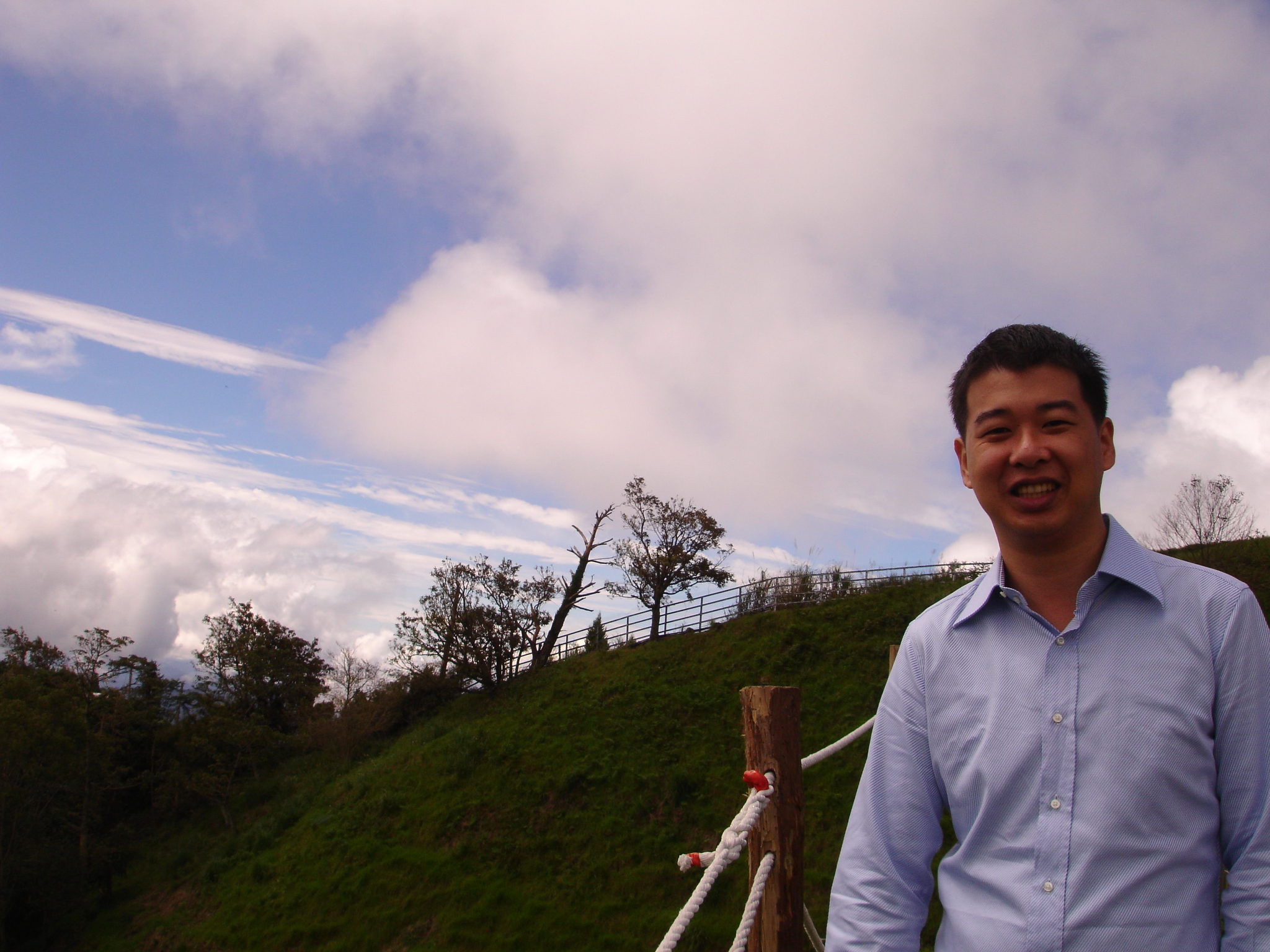 a man standing in front of a green hill