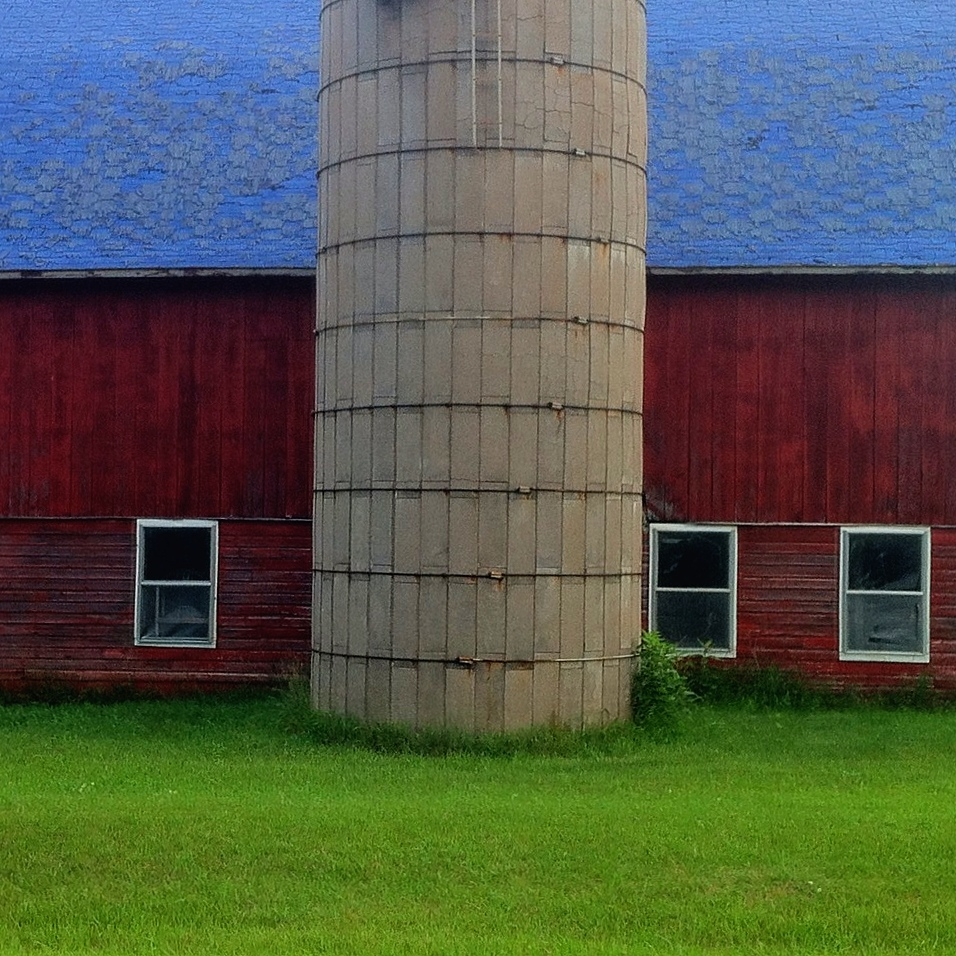 the large silo stands tall near the barn