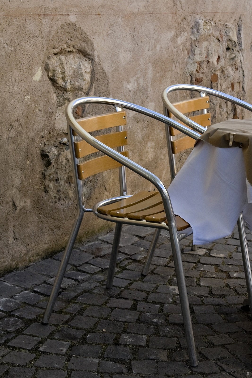 two chairs sitting next to a table with an umbrella on it