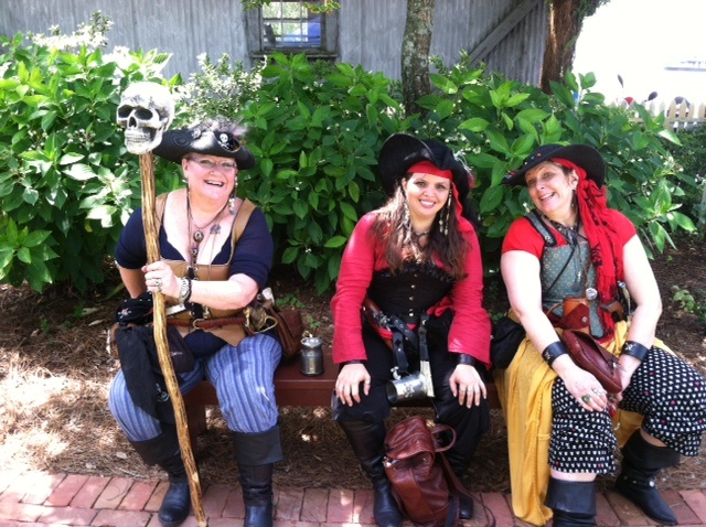 three women in pirate costumes sitting next to each other