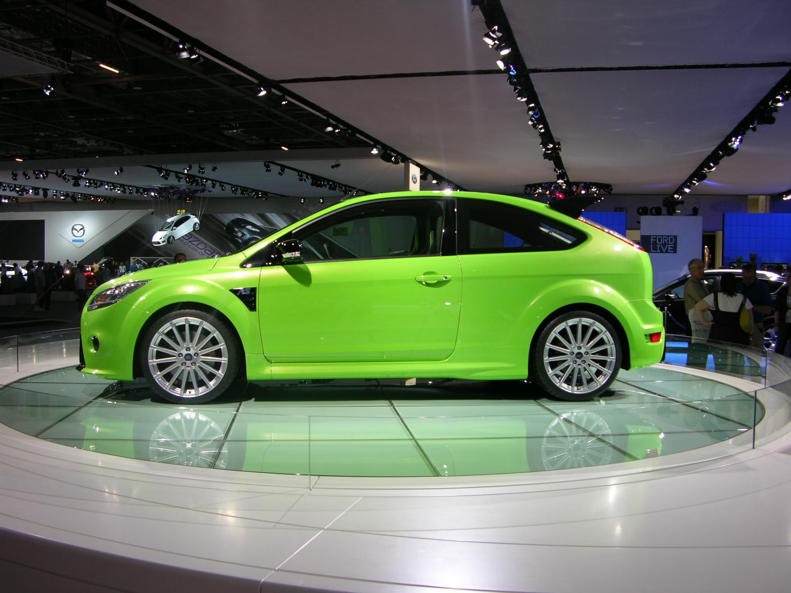 a green car is on display in a show room