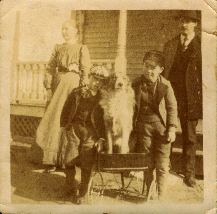 three adults and one dog pose with an older gentleman