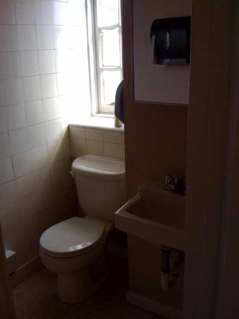 small white bathroom with toilet, sink and window