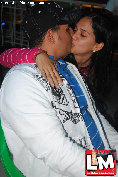 a young man and woman kiss at night