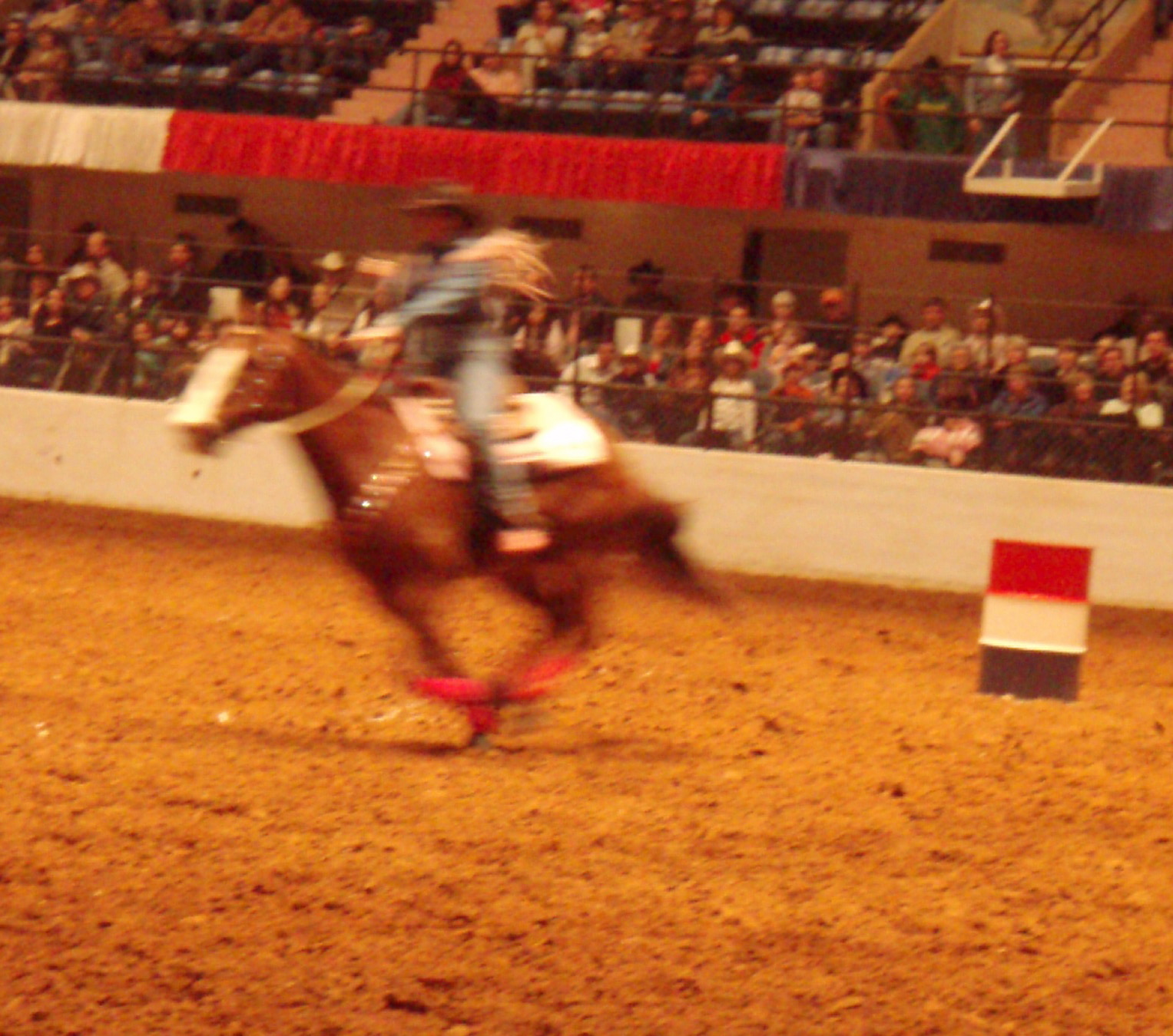 the horse rider is rounding up the flag pole