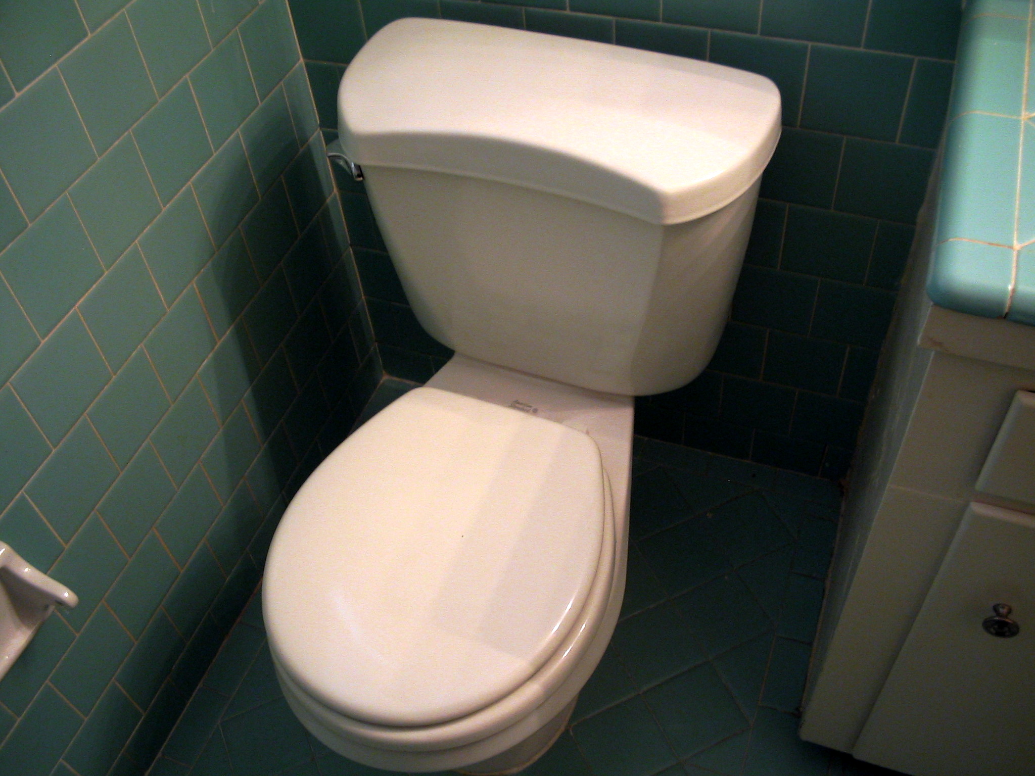 a very white toilet sitting in a small bathroom