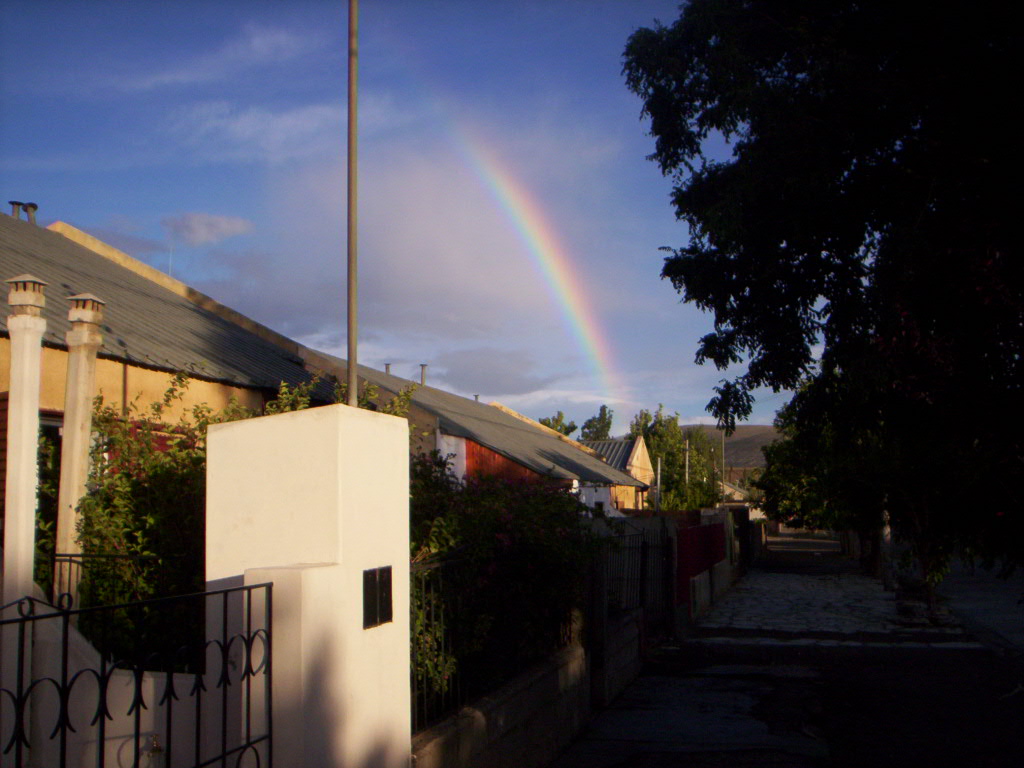 a rainbow is seen over a residential area with houses