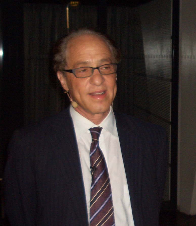 an older man wearing glasses, a striped tie, and a suit jacket