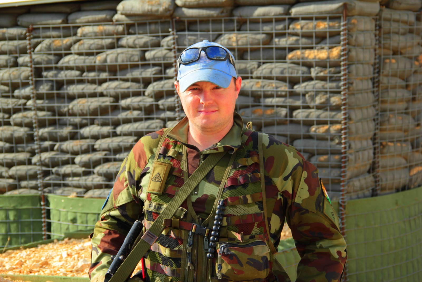 a man standing in front of a cage with military equipment