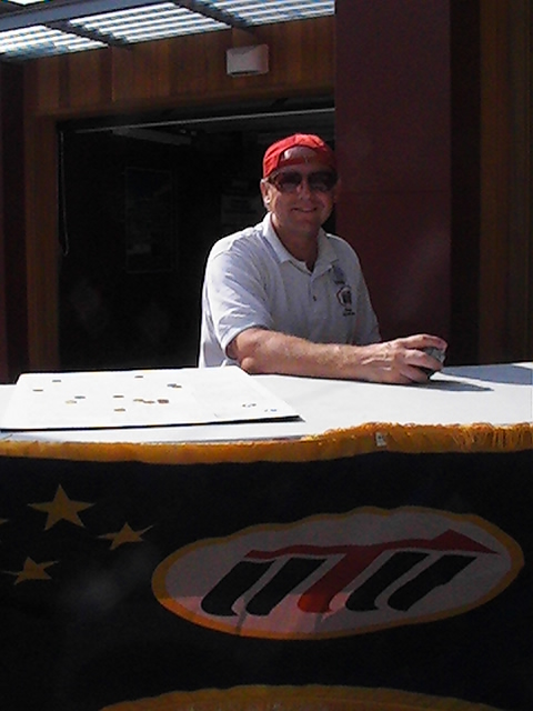 a man wearing a red hat and sunglasses sitting at a table
