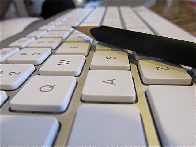 an opened knife lies on a computer keyboard