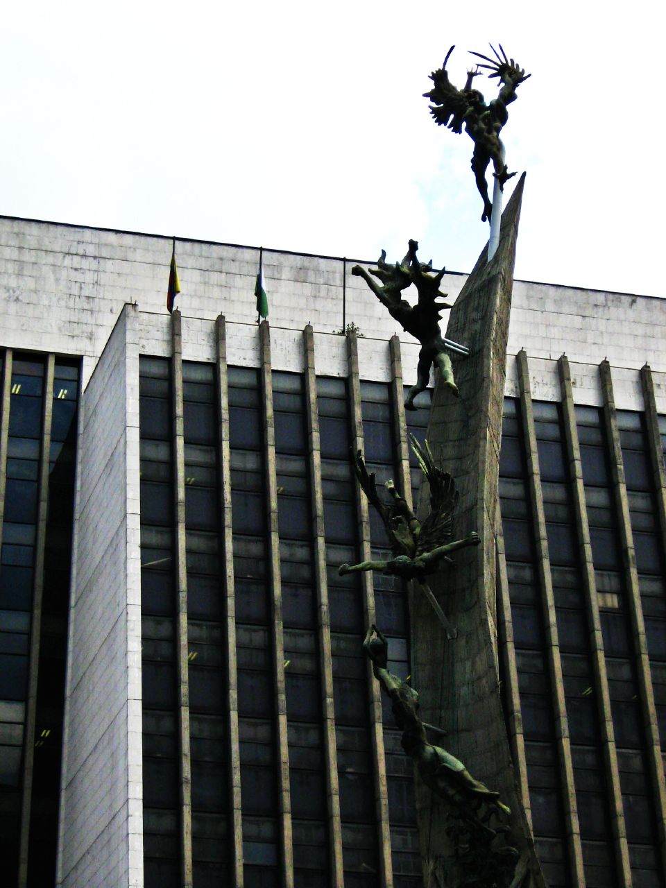 a tall sculpture near a very tall building