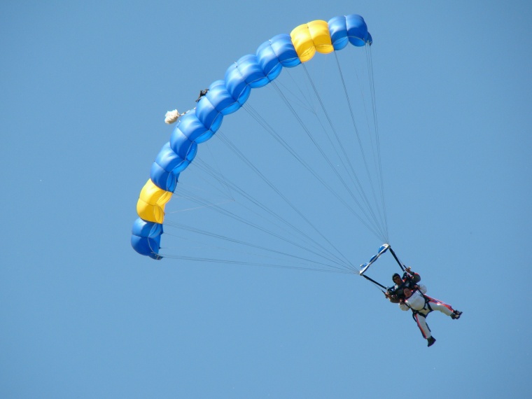 two people flying on a blue kite