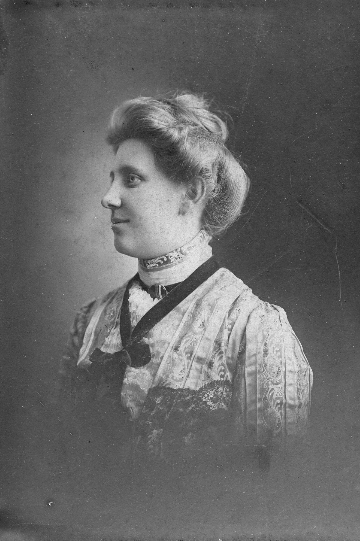 an old black and white po of a woman wearing a dress