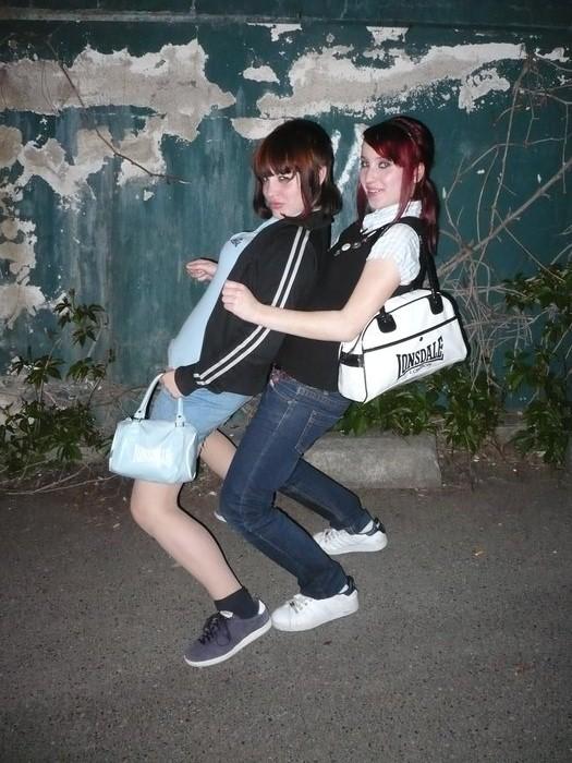 two people posing for a po while holding onto a purse