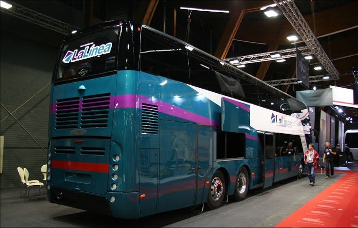 a blue, purple, and white bus on display in a building