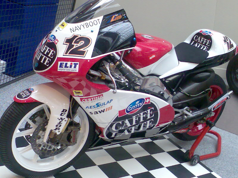 a motorcycle is parked on a checkered black and white floor
