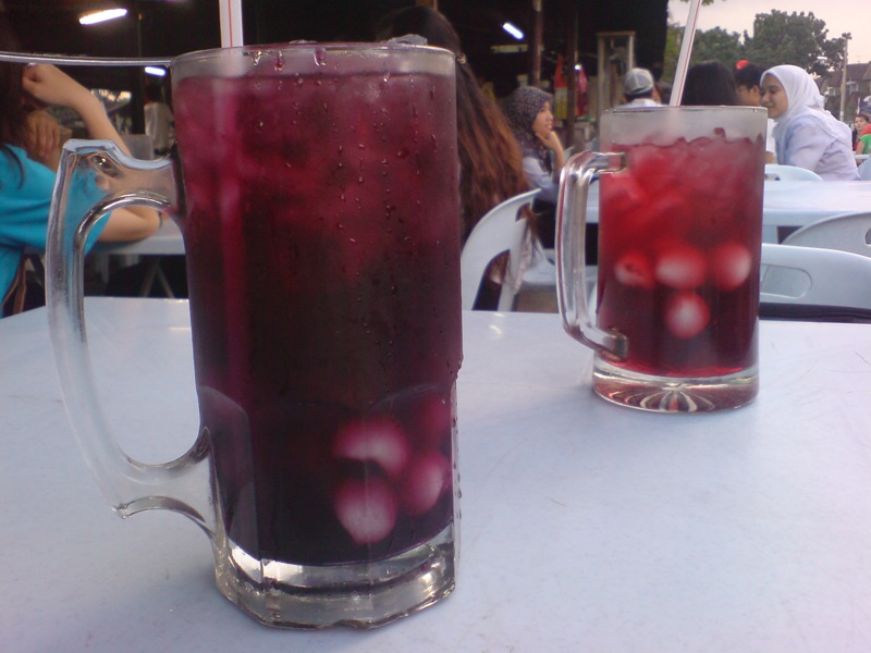 a white table with two cups full of red liquid