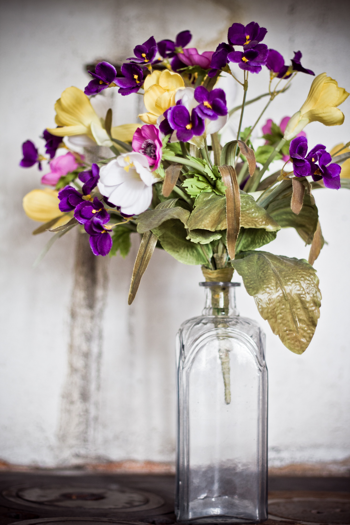 a vase filled with purple and yellow flowers