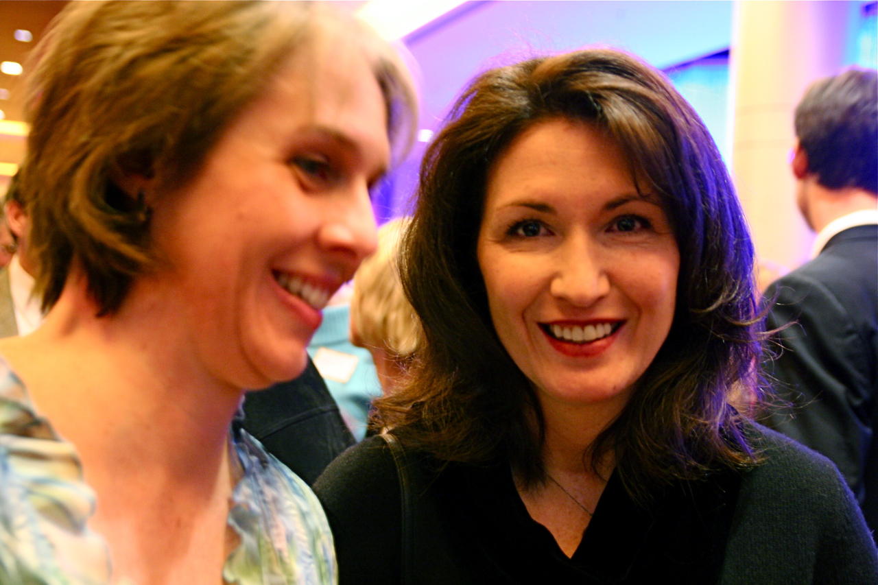 two women sitting and posing for the camera