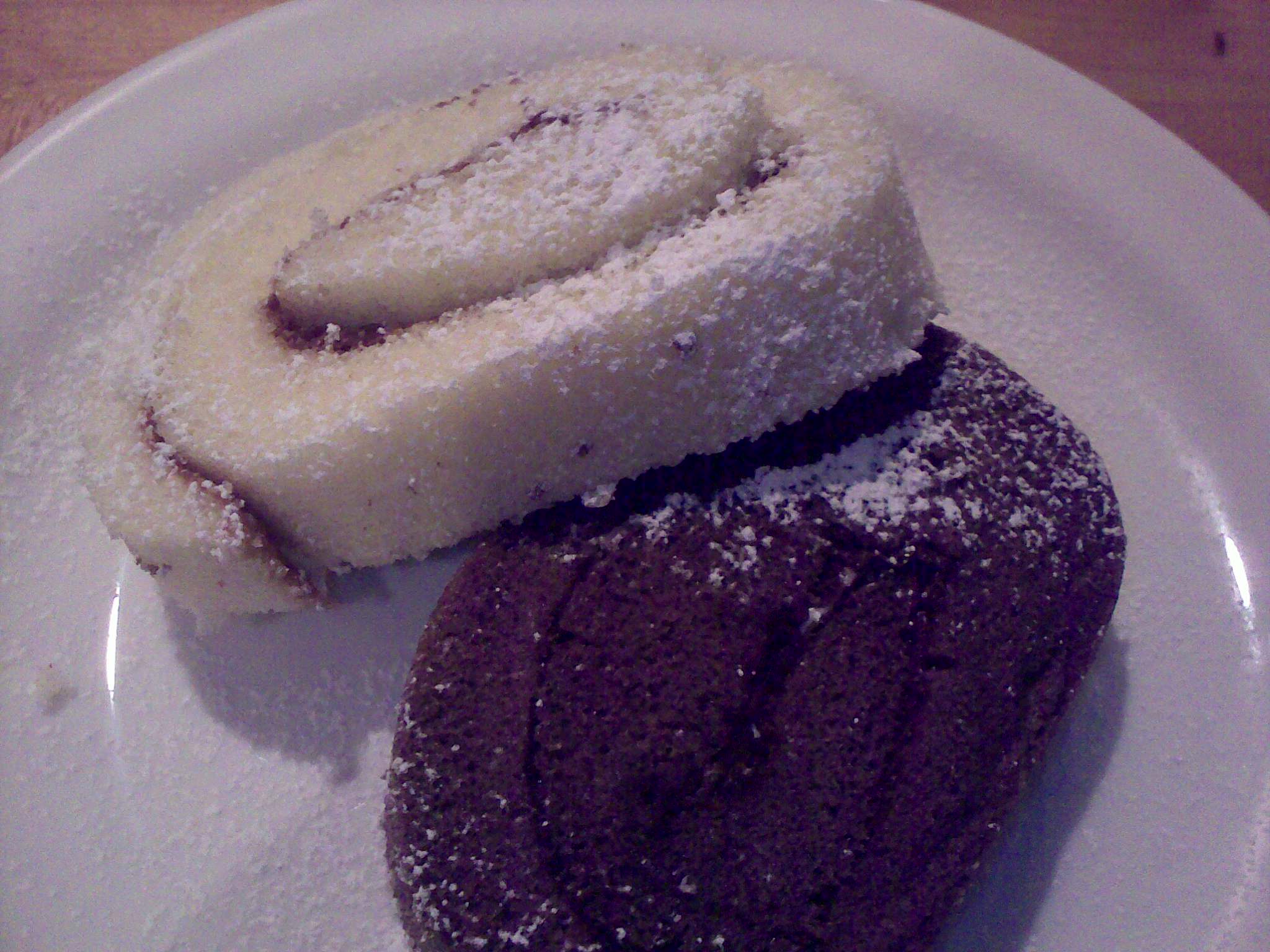 two dessert foods on white plate with wooden table