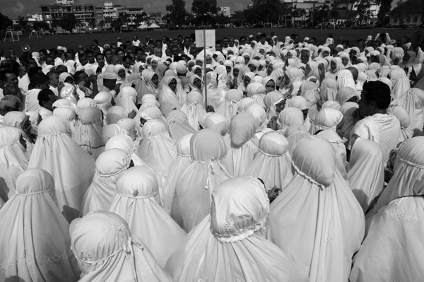 a crowd of women with long white veils in a black and white po