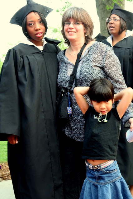 there are two people, one young child, wearing black caps and gowns