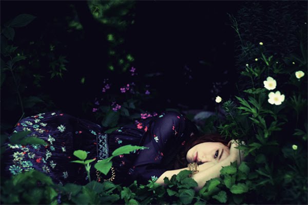 a woman with brown hair laying in the grass