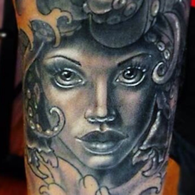 a tattoo with a woman with a head of flowers