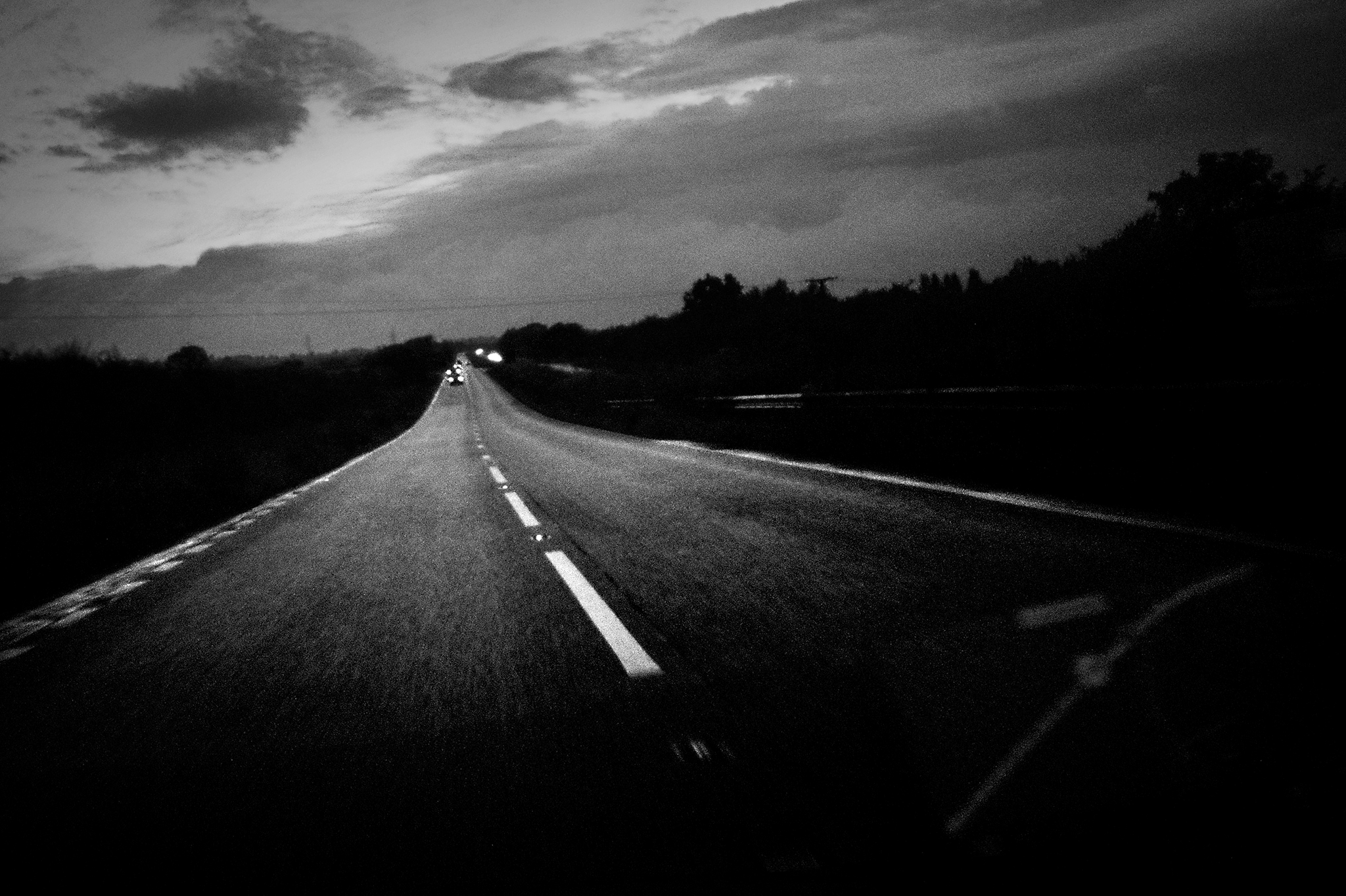 an empty highway at night with cars passing